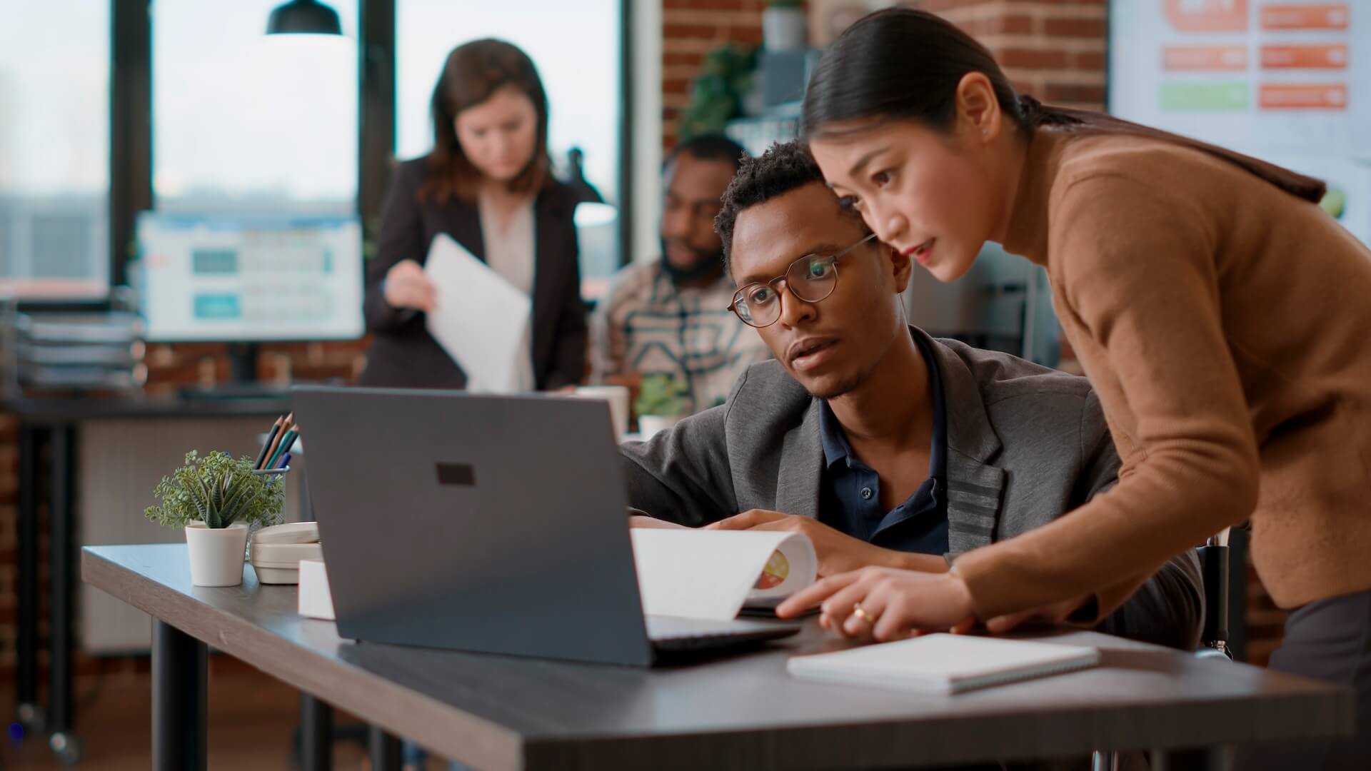 People working and looking at the screen of a laptop | Featured image for Best Features of Microsoft Edge Blog on Connected Platforms